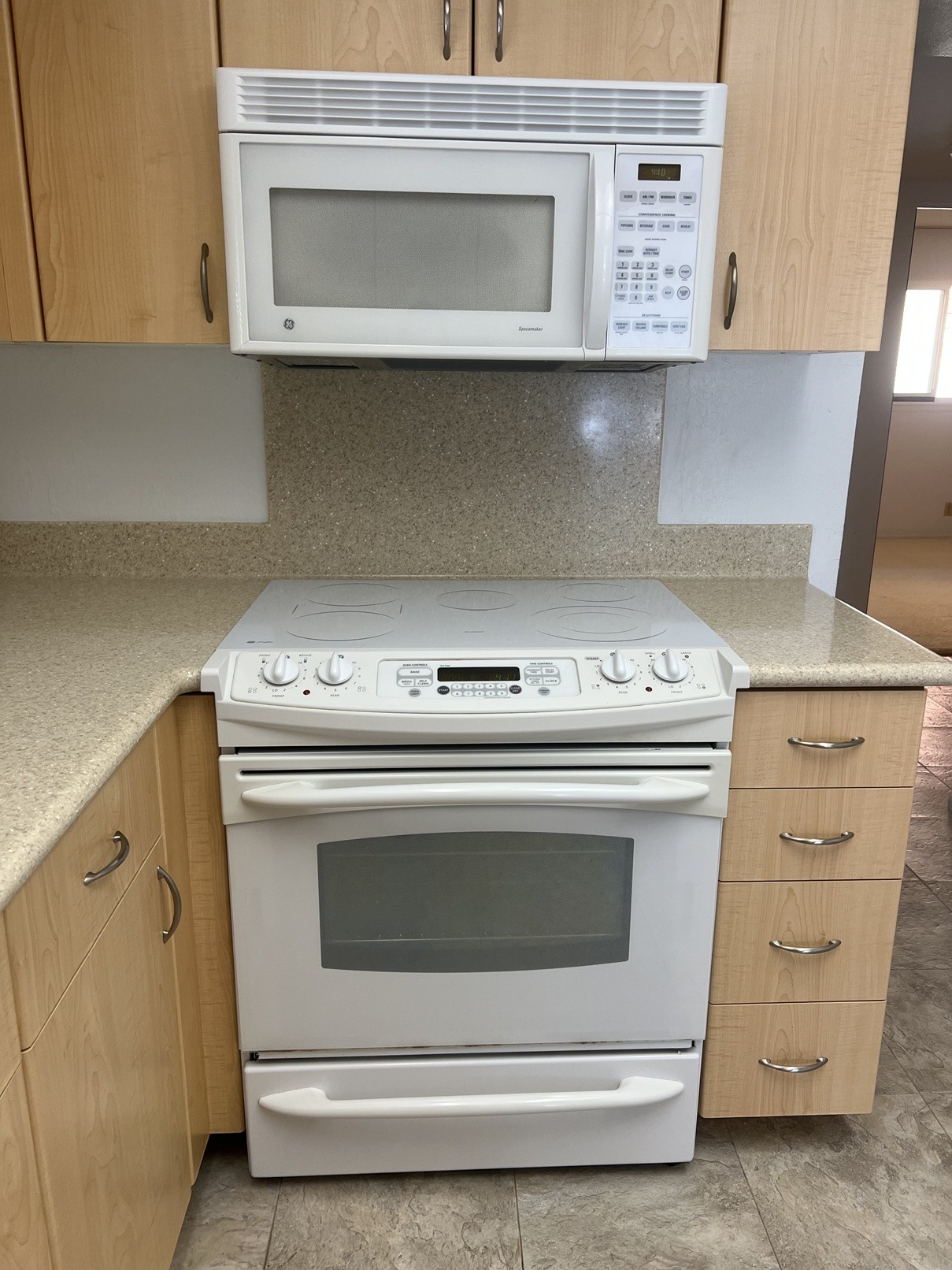 A white oven and microwave in a kitchen.